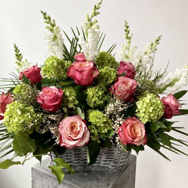 Pink roses and green hydrangeas in a wicker basket
