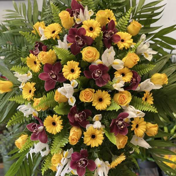 Large tropical bouquet with yellow roses, yellow daisies, and burgundy orchids