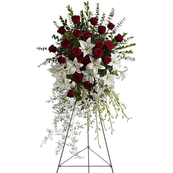 Standing spray of red roses and white lilies with orchids on a tall metal easel