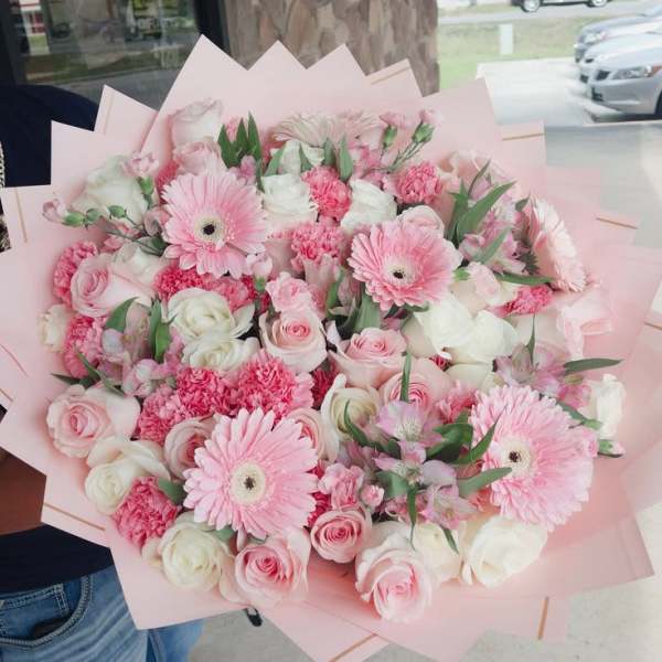 Pink and white bouquet with gerbera daisies and roses in pale pink wrap