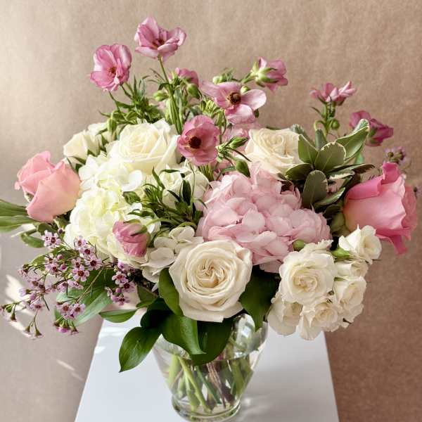 Pink and white flower arrangement in a clear glass vase