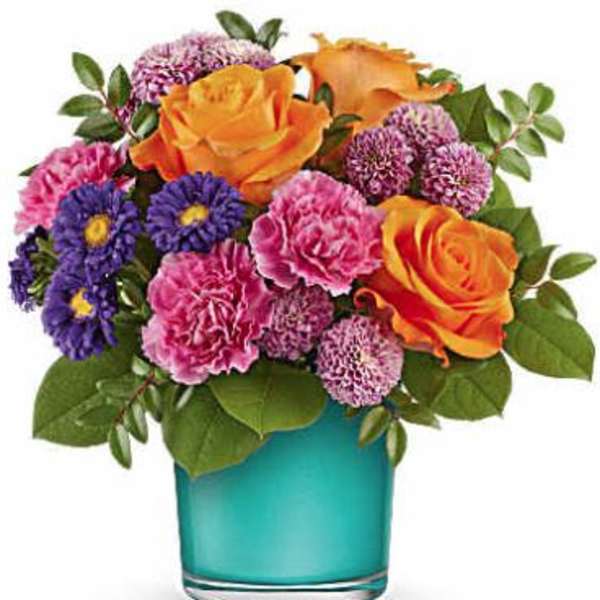 Bouquet of orange roses, pink carnations, and purple daisies in a blue vase