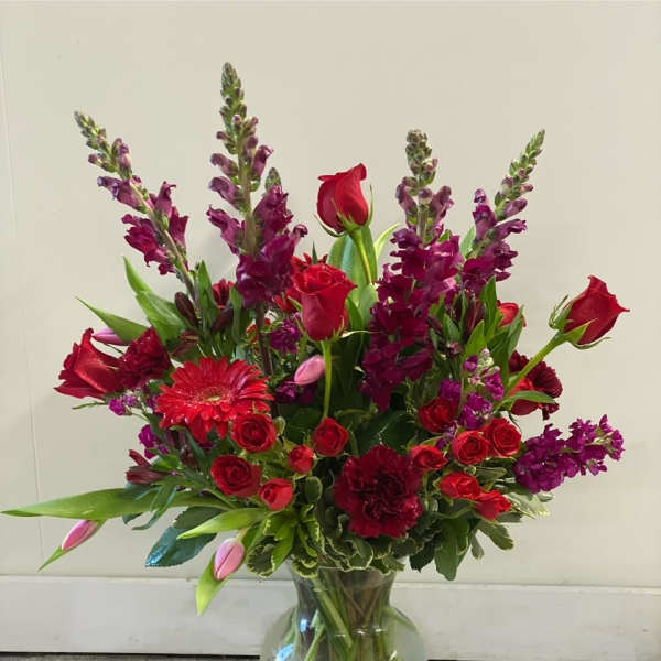 Red and purple mixed bouquet in a clear glass vase