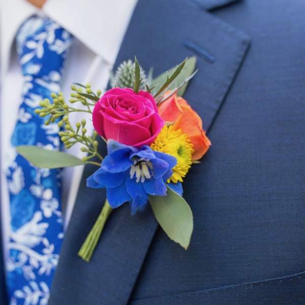 Colorful boutonniere pinned to a navy suit jacket