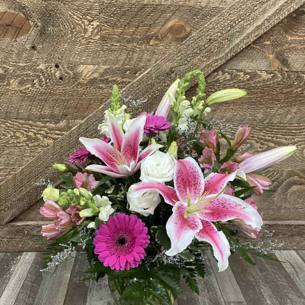 Pink lilies and gerbera daisies in a glass vase