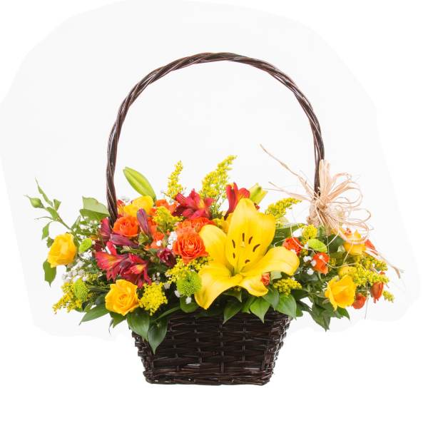 Basket arrangement with yellow lilies, roses, and red flowers