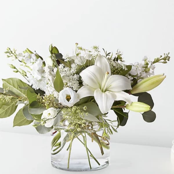 White lily bouquet in a clear glass vase