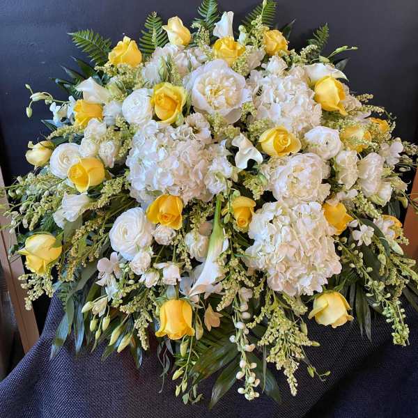 Large bouquet of white and yellow flowers with fern foliage