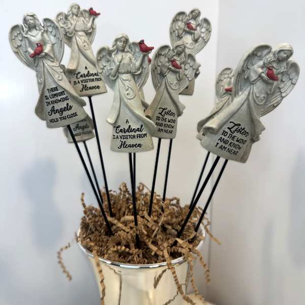Angel figurines with cardinal accents in a white container