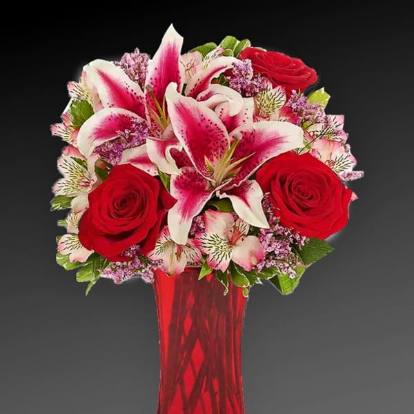 Bouquet of red roses and pink lilies in a red vase