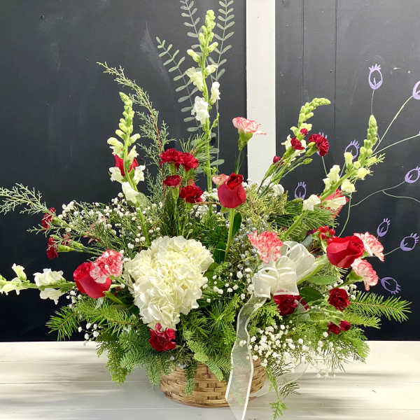 Basket arrangement with red and white flowers and a sheer ribbon