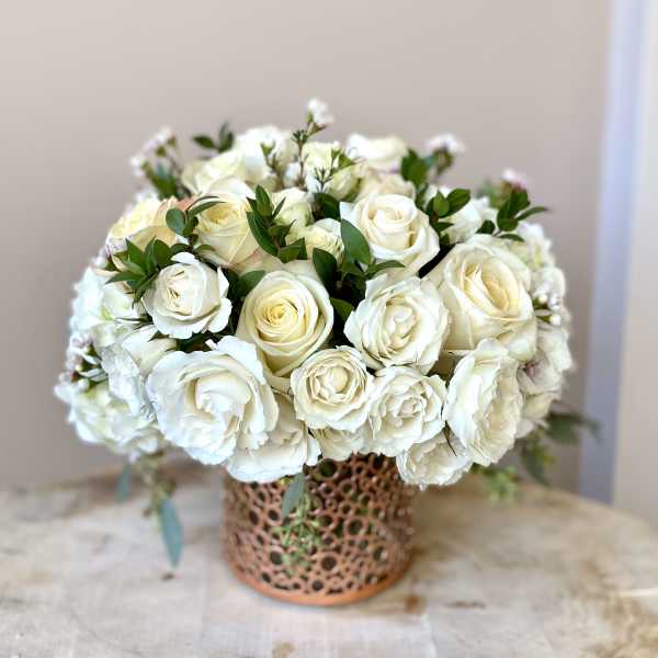 White rose bouquet in a decorative copper vase