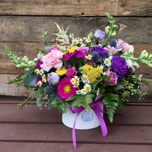 Mixed bouquet in a white hatbox with a purple ribbon