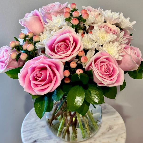Pink roses and white daisies in a clear glass vase