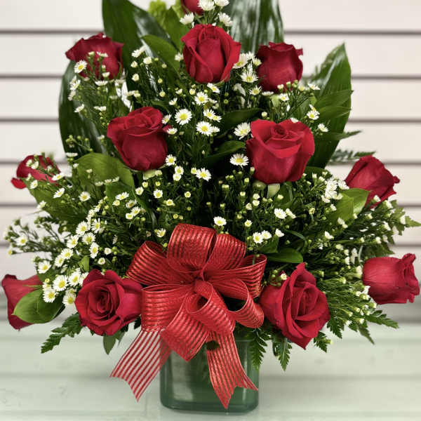 Red roses with white daisies in a green vase and red ribbon