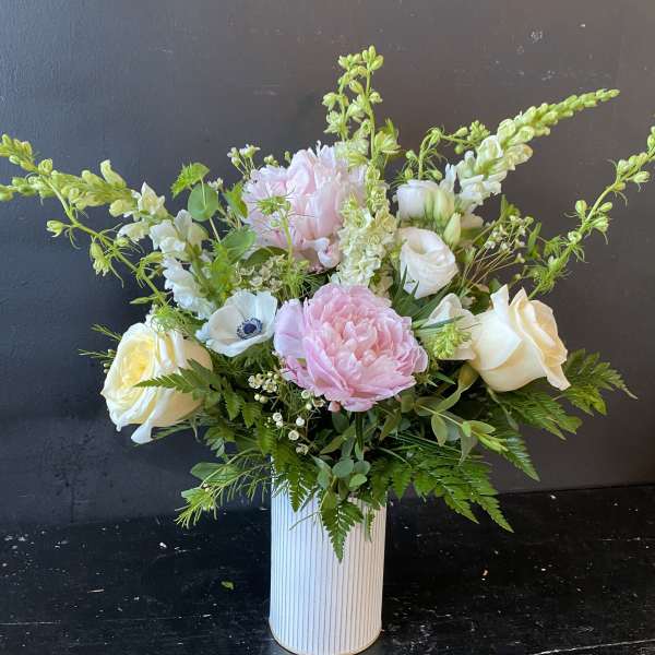 Pink and white floral arrangement in a ribbed white vase