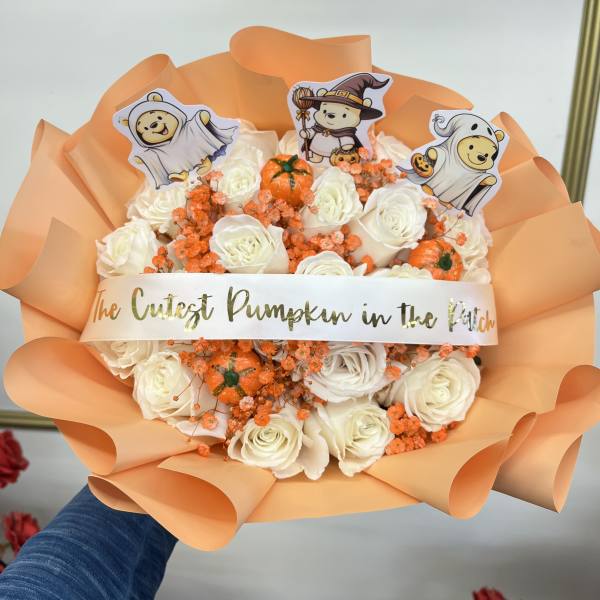 White rose bouquet with orange accents and Halloween character picks
