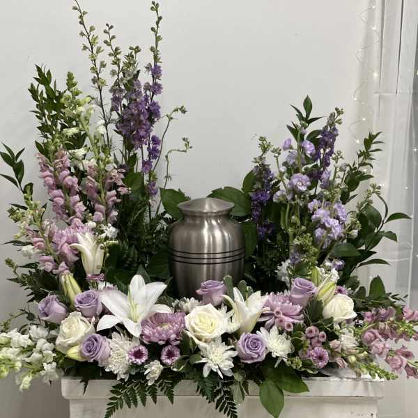 Lavender and white floral arrangement around a silver urn