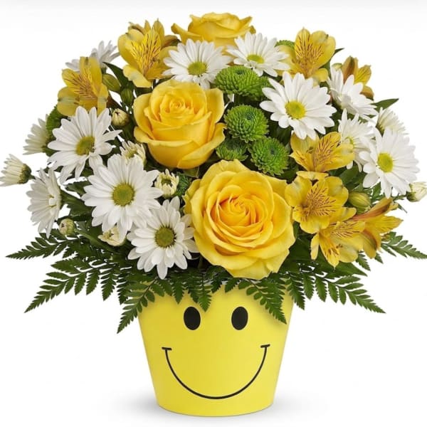 Yellow roses and white daisies in a smiley-face pot
