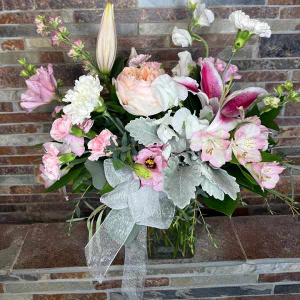 Pink and white mixed bouquet in a glass vase with a silver ribbon