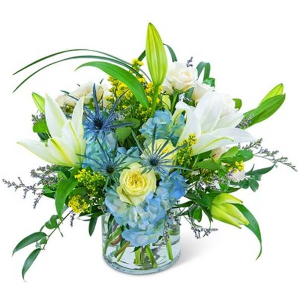 White lilies and blue hydrangeas in a glass vase