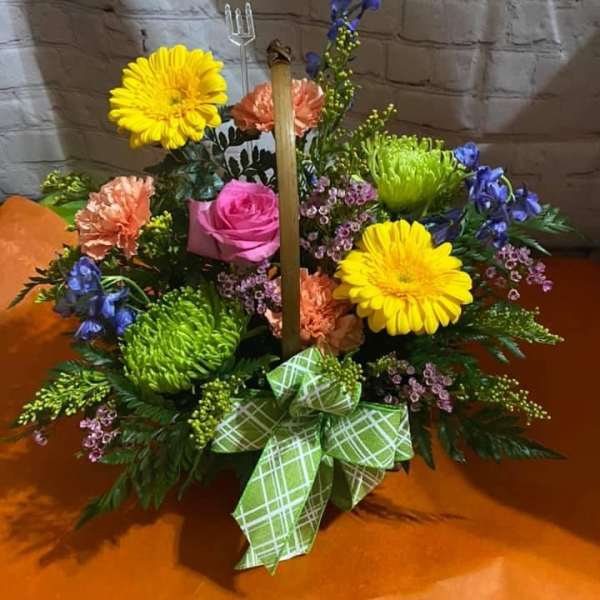 Colorful floral basket with gerbera daisies, roses, and a green plaid bow