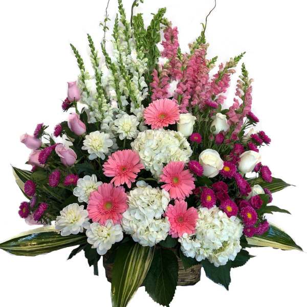 Pink and white mixed flower arrangement in a basket