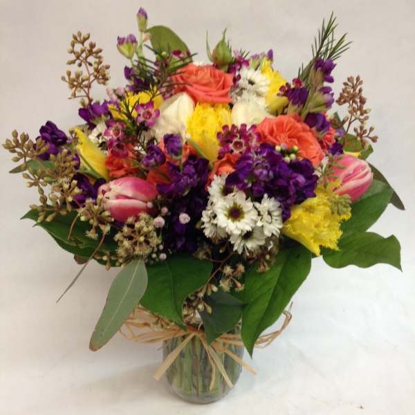 Mixed bouquet of colorful flowers in a glass vase
