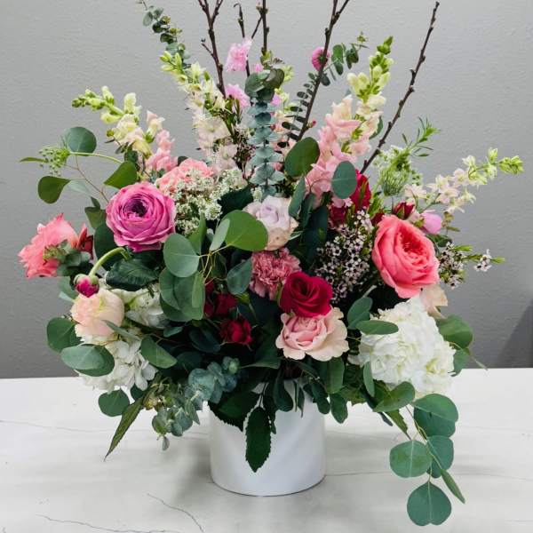 Mixed pink and white floral arrangement in a white vase