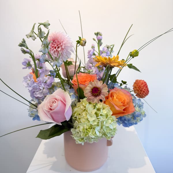 Mixed pastel flower arrangement in a pink vase