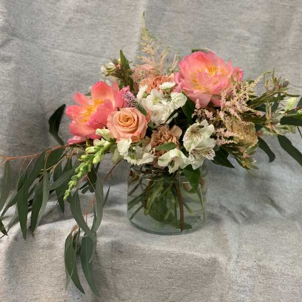 Pink and peach floral arrangement in a clear glass vase