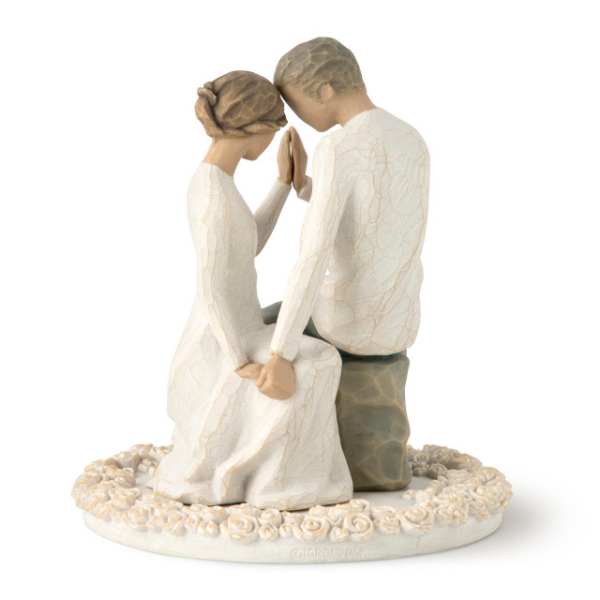 Figurine of a seated couple holding hands on a floral base