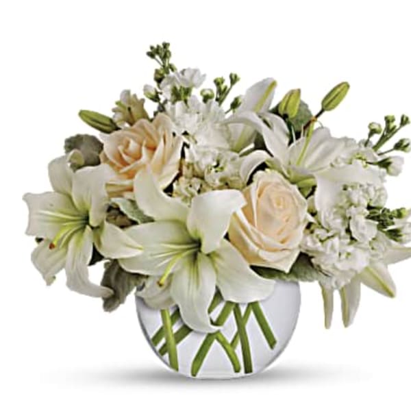 White lilies and cream roses in a round glass vase