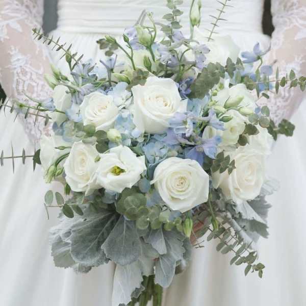 White rose bridal bouquet with pale blue flowers and eucalyptus