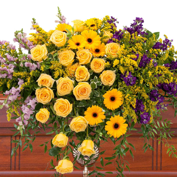 Yellow roses and gerbera daisies with purple flowers in a vase