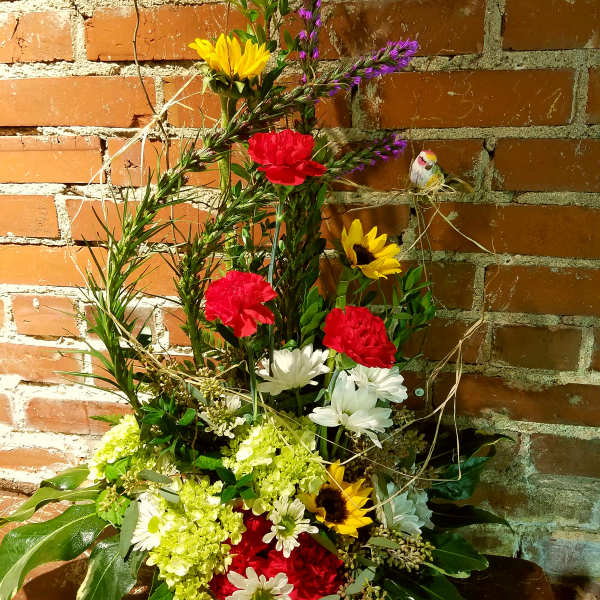 Tall mixed bouquet with sunflowers, carnations, and daisies