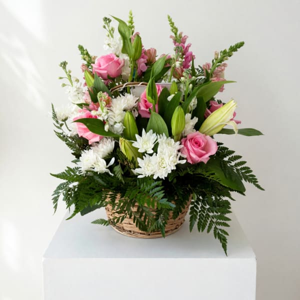 Pink roses and white lilies in a wicker basket