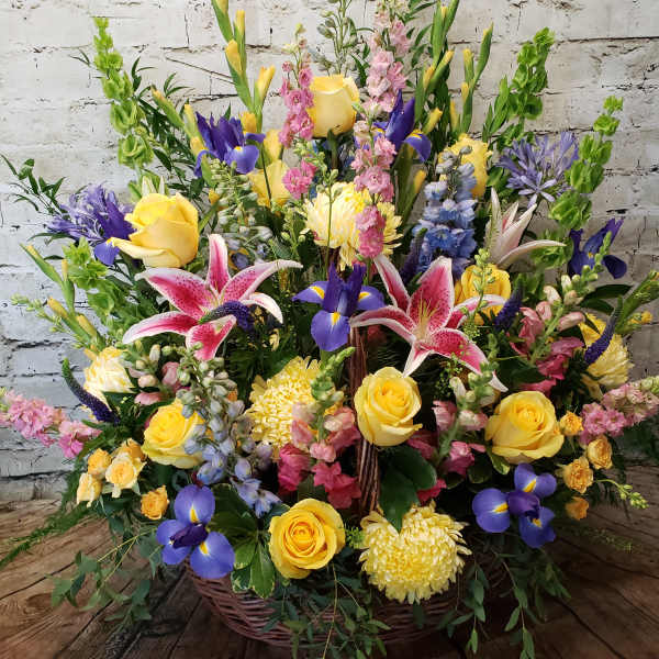 Large basket arrangement with yellow roses, pink lilies, and purple irises