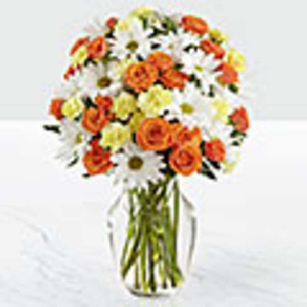 Bouquet of orange roses and white daisies in a clear glass vase