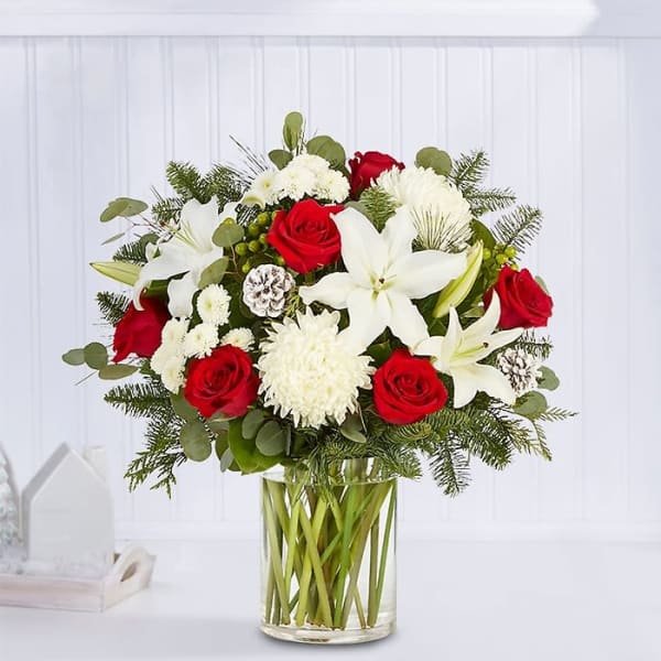 Red roses and white lilies in a clear glass vase