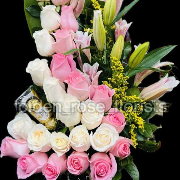 Pink and white roses with lilies in a tall bouquet
