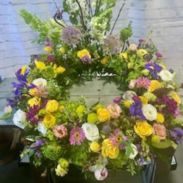Large wreath of mixed flowers in yellow, purple, white, and pink