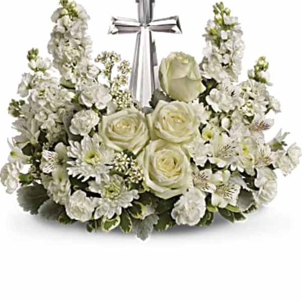 White floral arrangement with roses and a silver cross centerpiece
