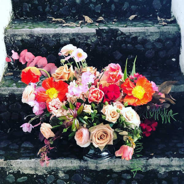 Mixed bouquet of peach, pink, and orange flowers on stone steps