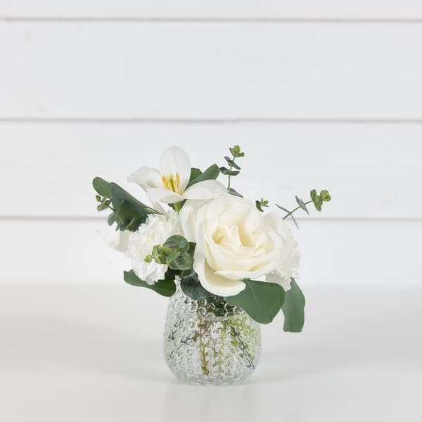 White rose and lily arrangement in a textured glass vase