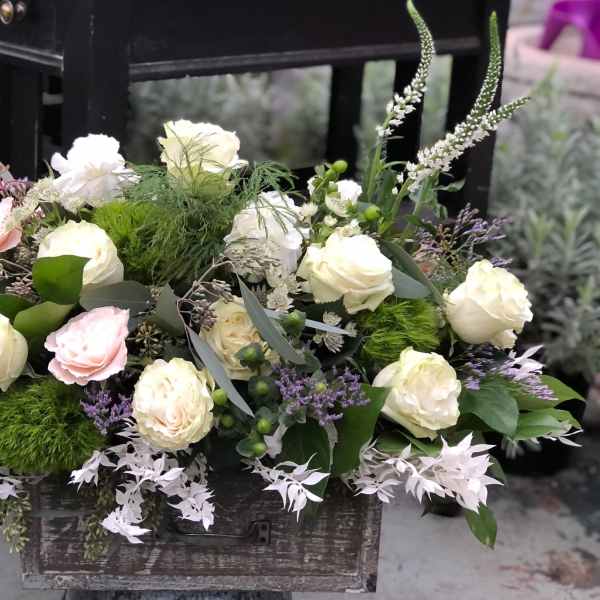 Mixed white and blush roses arranged in a rustic wooden box
