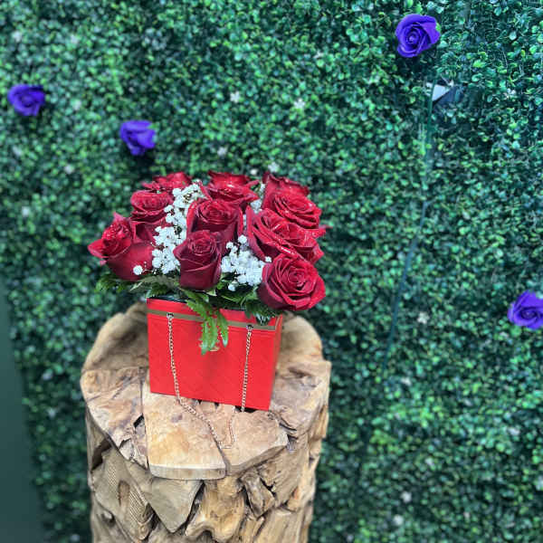 Red roses in a red box with white filler flowers