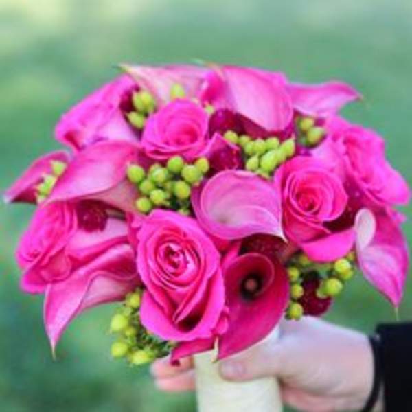 Handheld bouquet of hot pink roses and calla lilies