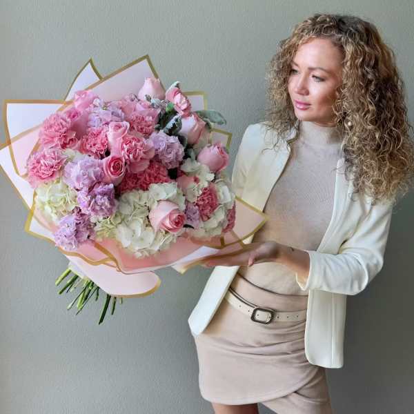 Large pink and white bouquet of roses and carnations wrapped in pastel paper