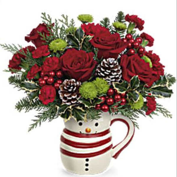 Red roses in a snowman mug with pinecones and holiday greenery